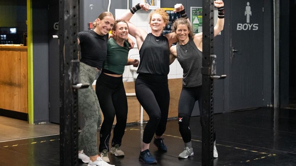 Vier sportsters na de training, armen in de lucht