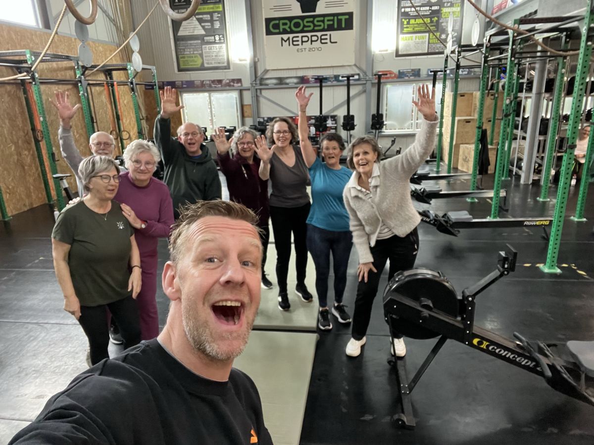 Sierk maakt een selfie met de lachende en zwaaiende ZilverFitness-groep in de zaal